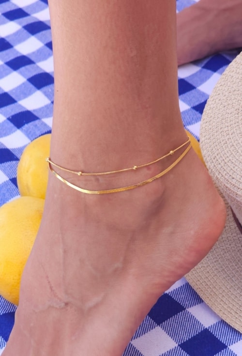 TORNOZELEIRA DUPLA COM FITA E BOLINHAS EM AÇO INOX DOURADO TZM022-AD